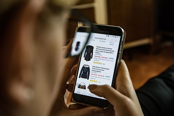 Person shopping for clothes on Amazon on their cell phone