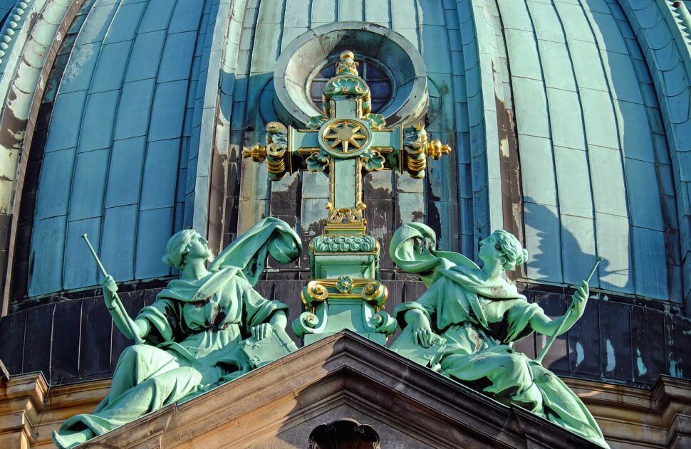 An image showing two statues by a cross at the Berlin Cathedral. 